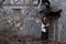 Sad gloomy cityscape of a medieval European street with a woman standing near an old house