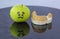 Sad green apple crying next to plaster model of lower teeth