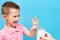 Sad harmful little kid refusing to drink milk showing stop gesture