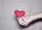 sad knitted heart on the palm. The concept of separation of people, finished relationships, sadness.