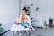 Sad lady drinking beverage while sitting alone at desk in bedroom