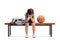 Sad little basketball player sitting on a bench and crying