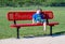 Sad little boy alone on a buddy bench