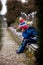 Sad little boy, sitting on a grave in a cemetery