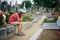 Sad little boy, sitting on a grave in a cemetery, feeling sad