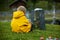 Sad little child, blond boy, standing in rain on cemetery, sad person, mourning