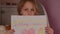 Sad little girl is holding poster with inscription I am staying home,close up