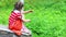 Sad little girl in skirt sits on stone