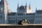 Sad little tank with parliament building in background, the hidden mini statue of Budapest, Hungary