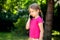 Sad lone little school age girl, child talking on the phone, smartphone outside. Unhappy, downhearted kid alone, phone call sad