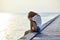 Sad lonely beautiful woman sitting on the pier