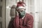 Sad and lonely Christmas lockdown during covid19 - depressed and tired man in Santa Claus hat and face mask home alone suffering