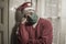 Sad and lonely Christmas lockdown during covid19 - depressed and tired man in Santa Claus hat and face mask home alone suffering