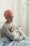 Sad lonely sick girl with cancer hugging plush toy in the hospital