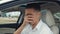 Sad male businessman crying while sitting in a car. Crisis and problems in business.