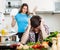 Sad man with angry wife at kitchen