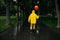 Sad man with balloon walking in park in rainy day