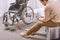 sad man with disability sitting on bed, wheelchair