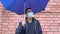 Sad man in mask standing alone under the umbrella, social distance, self isolation, quarantine concept