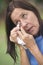 Sad mature woman tissue cleaning tears in eye
