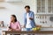 Sad millennial european woman with smartphone ignores offended angry screaming husband at kitchen