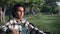 Sad mixed race guy waiting meeting date at summer sunny park bench checking time outdoor closeup