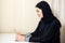 Sad Muslim busy business woman holding a tablet at home or office