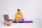 Sad obese woman sits on a rug in front of a laptop. Lazy to do physical exercises. Heavy weight loss. Background is an