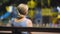 Sad old female sitting on playground bench and looking at children, infertility