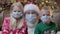 Sad portrait children and Santa Claus in medical protective masks from coronavirus pandemic. Blond boy and girl together