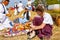 Sad pretty girl sits on the ground with her family. Outdoor retro breakfast like in old times