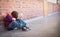 Sad pupil sitting alone in corridor