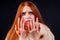 Sad redhaired ginger fashion victim woman with blood on her hands wearing natural fur coat and crying,studio black