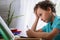 Sad schoolboy puts his hand under his head and looks at book