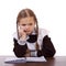 Sad schoolgirl sits at a school desk