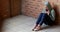 Sad schoolgirl sitting alone on floor