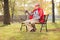 Sad senior in superhero outfit sitting in park