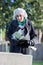 Sad Senior Woman With Flowers Standing By Grave