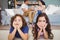 Sad siblings lying on carpet while parents sitting in background