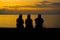 Sad Siluet people on sunset background, Silhouette three women sitting on the beach at Sunset