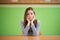 Sad student sitting in classroom with her head in hands. Education, high school, bullying, pressure, depression.