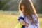 A sad teenage girl holds a Ukrainian flag to her chest