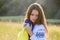 A sad teenage girl holds a Ukrainian flag to her chest