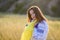 A sad teenage girl holds a Ukrainian flag to her chest