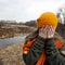 Sad teenager in orange knitten hat