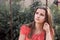 Sad unhappy teen girl with long brunette hair sitting on a swing sadly looking up