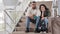 Sad upset angry tired multiethnic couple african american man and hispanic woman sitting on steps stairs with suitcase