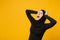 Sad upset crying confused young arabian muslim woman in hijab black clothes posing isolated on yellow wall background