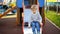 Sad and upset little lonely boy sitting on slide at playground
