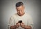 Sad upset middle aged man seeing bad news email text on cellphone